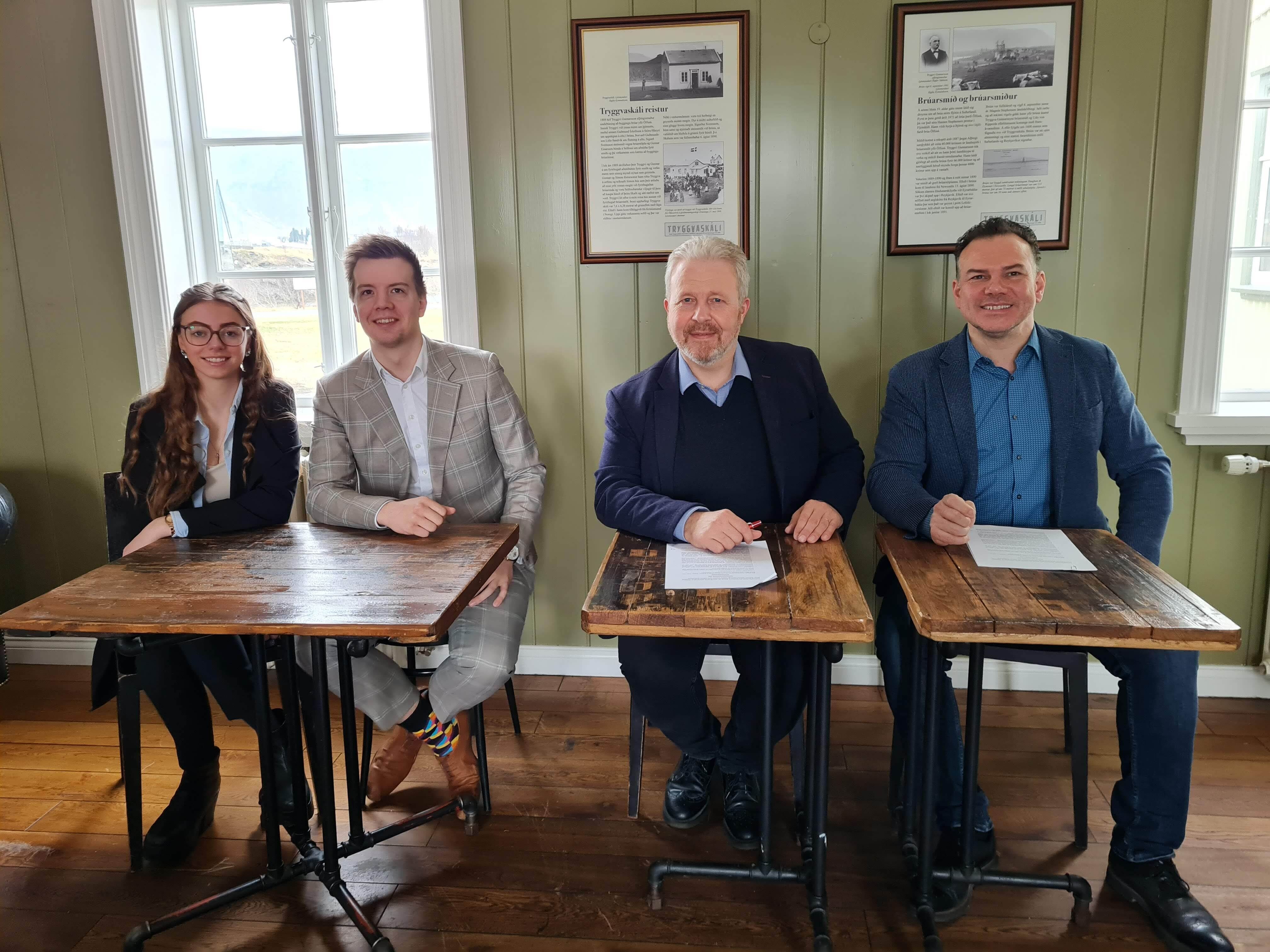 four people sitting in front of a table